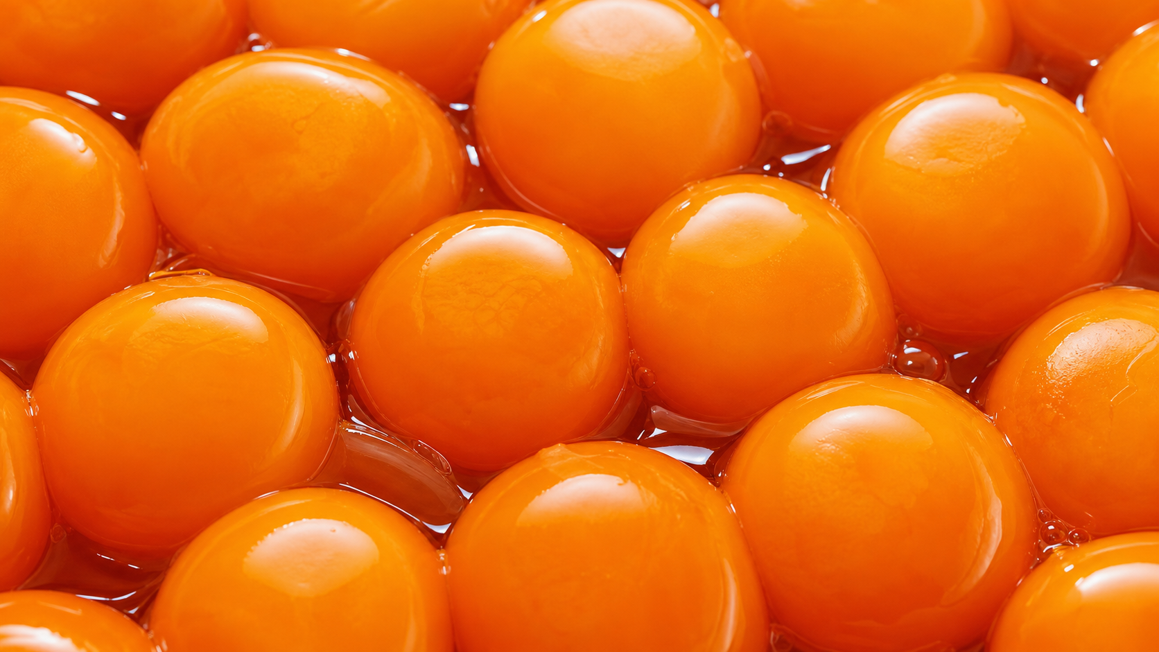 A close-up arrangement of rich orange egg yolks